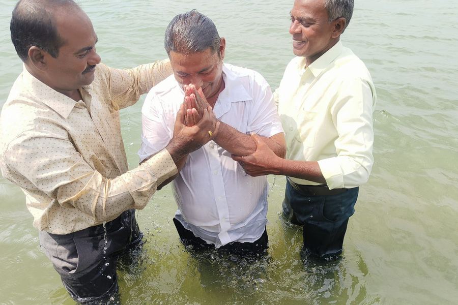A believer being baptised in a village pond
