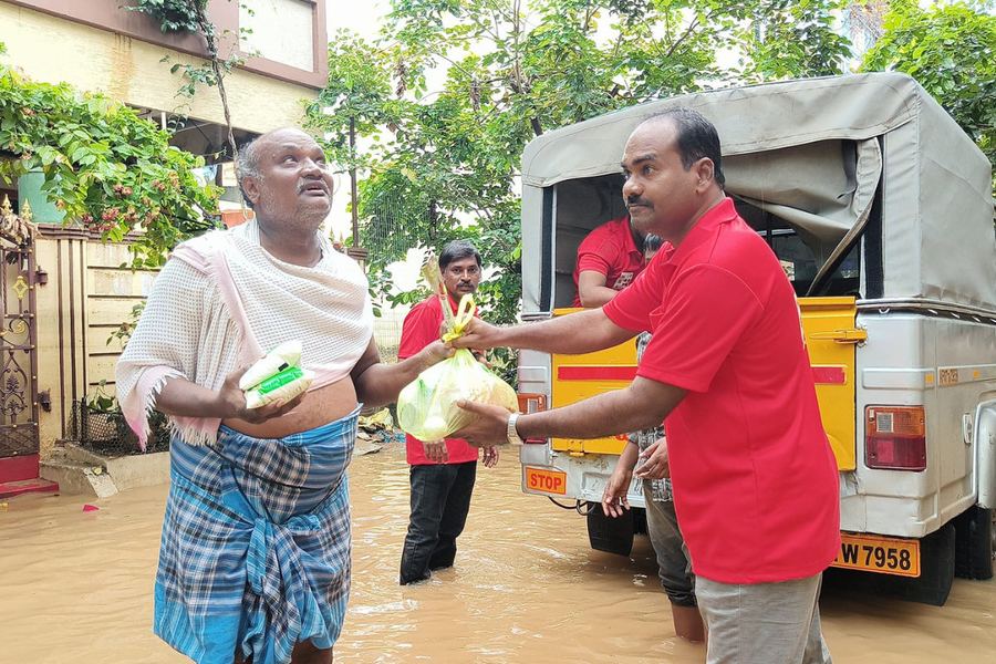 Handing relief supplies to a man during flood relief